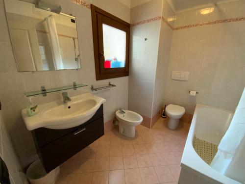 a bathroom with a sink and a toilet and a mirror at Patrizia Apartement in Chioggia