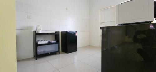 a room with a black refrigerator and a tv at Bertam Homestay Kepala Batas in Kepala Batas