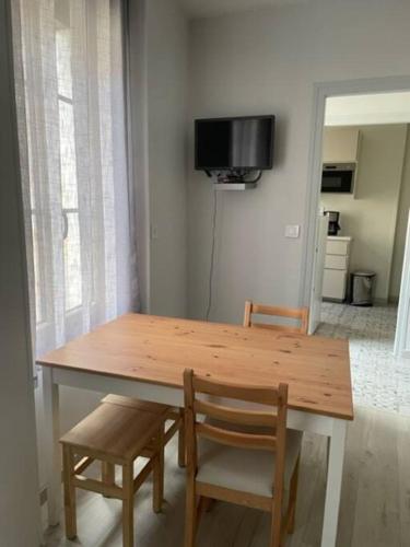 une table en bois avec deux chaises et une télévision dans l'établissement AU COEUR DE LA PUISAYE TOUT PRES DE GUEDELON, à Saint-Amand-en-Puisaye