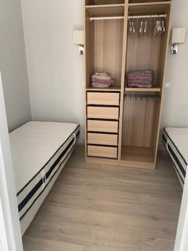 a small room with two beds and a closet at AU COEUR DE LA PUISAYE TOUT PRES DE GUEDELON in Saint-Amand-en-Puisaye
