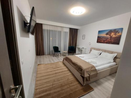a bedroom with a bed and a table and chairs at NoMi Ultracentral Apartments in Târgu-Mureş