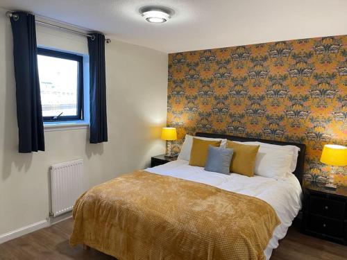 um quarto com uma cama grande e uma janela em River view Apartment em Glasgow