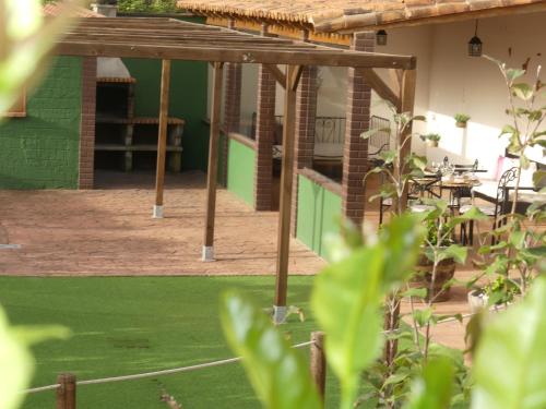 a patio with a green wall and a table and chairs at Holiday Home El Brezal in El Palmital