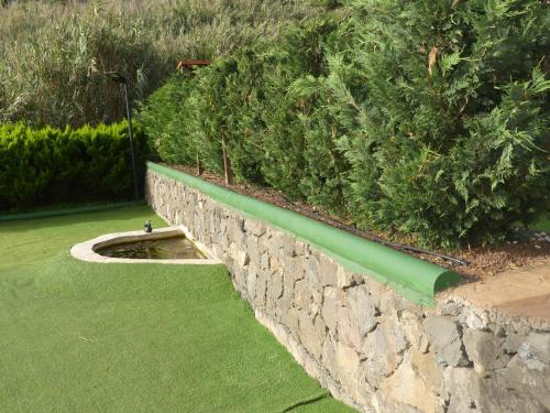 a stone retaining wall with a green pipe at Holiday Home El Brezal in El Palmital