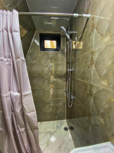 a bathroom with a shower with a shower curtain at Villa Ioseliani in Kumistavi