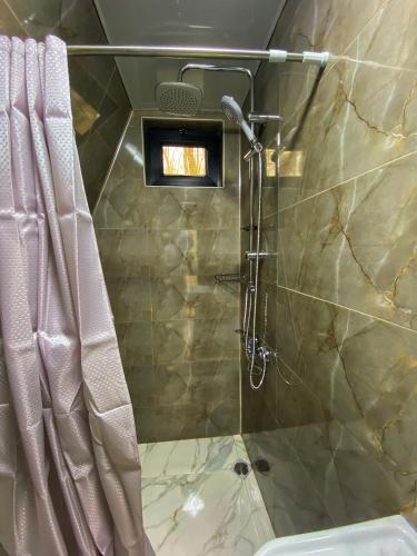een badkamer met een douche en een douchegordijn bij Cottage Villa Ioseliani in Kumistavi
