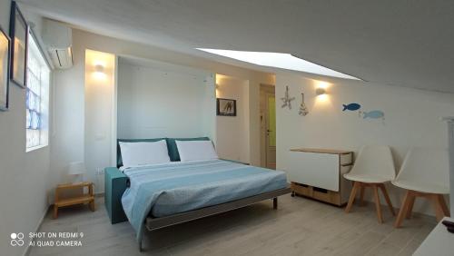 a bedroom with a bed and a table and chairs at Monolocale mansarda a Porto Santo Stefano Argentario in Porto Santo Stefano