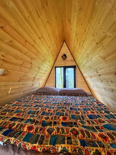 a bed in a room with a wooden ceiling at Cottage Villa Ioseliani in Kumistavi