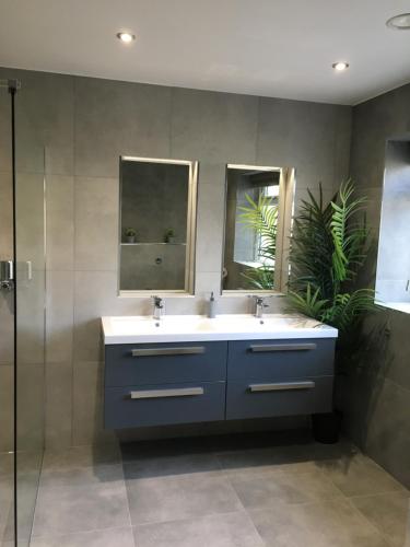 een badkamer met 2 wastafels en 2 spiegels bij Ancrum House in Gretna Green