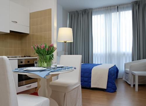 メストレにあるレジデンツァ ヴェネツィア アパートメンツのキッチン、テーブル、ベッド1台が備わる客室です。