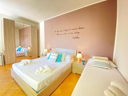 a bedroom with two beds and a writing on the wall at Maison Soleil Guest House Gallipoli in Gallipoli