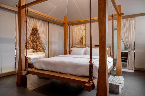um quarto com uma cama de dossel e um baloiço em Tian Xia Ju Motel em Yilan City