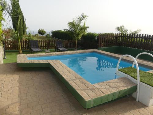 a swimming pool with a bench in a yard at Holiday Home El Brezal in El Palmital