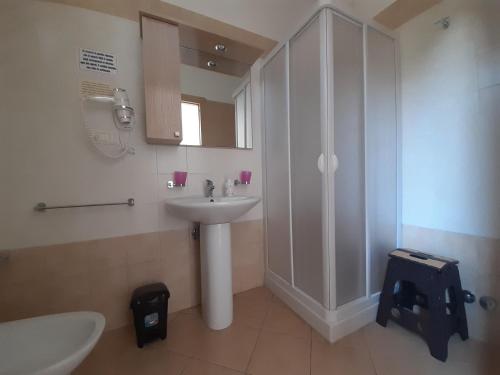 a white bathroom with a sink and a shower at B&B Borgo Minerva in Otranto