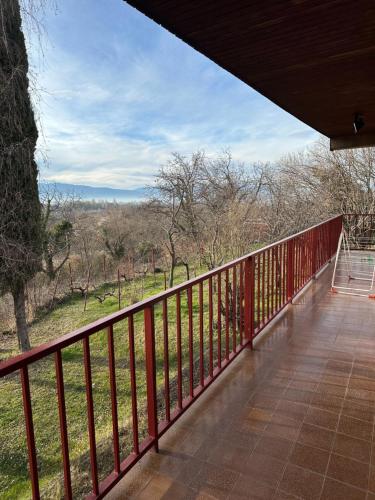 a balcony with a view of a field and trees at Vila Popovski in Ljubaništa