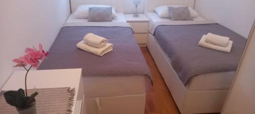 two beds in a small room with towels on them at Marys Home Apartment Međugorje in Međugorje