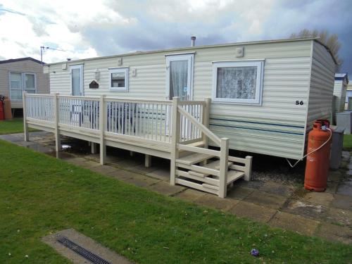 a mobile home with a porch and a fire hydrant at Seaways : The Westmorland SW:- 6 Berth, Enclosed Veranda in Lincolnshire