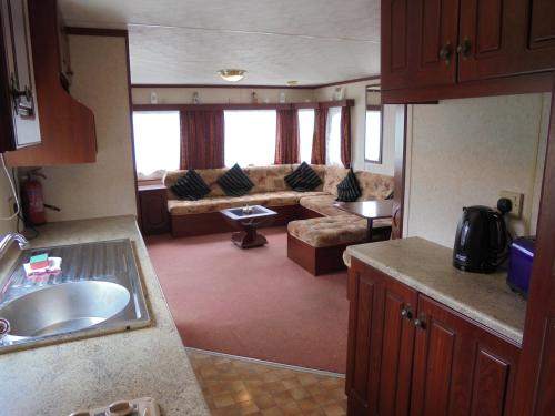 a kitchen and living room in an rv at Seaways : The Westmorland SW:- 6 Berth, Enclosed Veranda in Lincolnshire