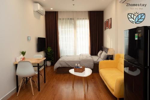 - un salon avec un canapé jaune et un lit dans l'établissement Vinhomes Smartcity-Căn hộ dich vụ -Zhomestay, à Phú Thú
