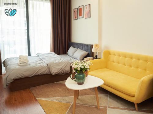un salon avec un lit, un canapé et une table dans l'établissement Vinhomes Smartcity-Căn hộ dich vụ -Zhomestay, à Phú Thú