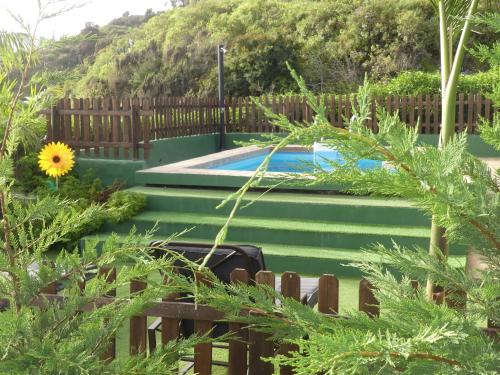 a swimming pool in a yard with a wooden fence at Holiday Home El Brezal in El Palmital