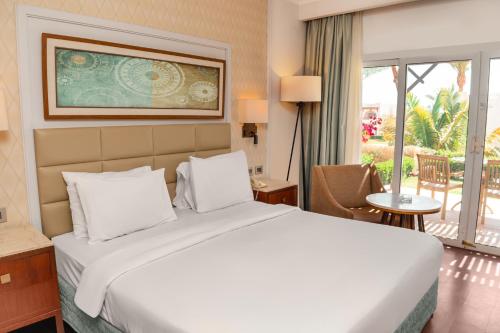 a bedroom with a large white bed and a balcony at Sharm Dreams Vacation Club - Aqua Park in Sharm El Sheikh