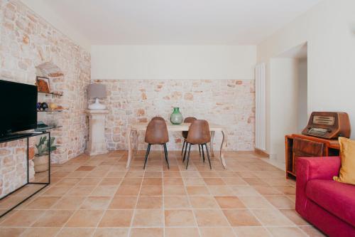 uma sala de estar com um sofá, uma mesa e cadeiras em Conte Orsini Apartment em Conversano
