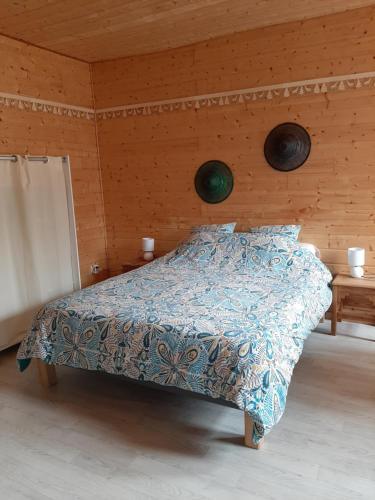 1 dormitorio con 1 cama con edredón azul en Studio dans bâtisse typique du Jura, 
