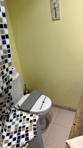 un baño con aseo con un letrero. en Truchas, en Astún