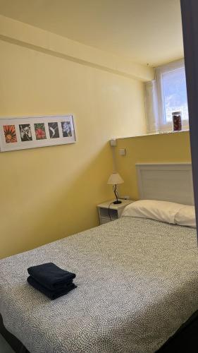 Un dormitorio con una cama con una bolsa negra. en Truchas, en Astún