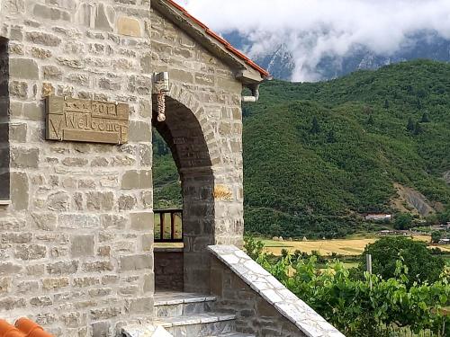 a stone building with an archway in front of a mountain at The Stone House in Përmet