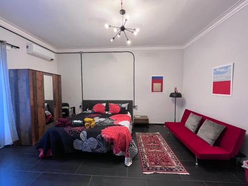 a bedroom with a bed and a red couch at Minardi Apartments in Vercelli