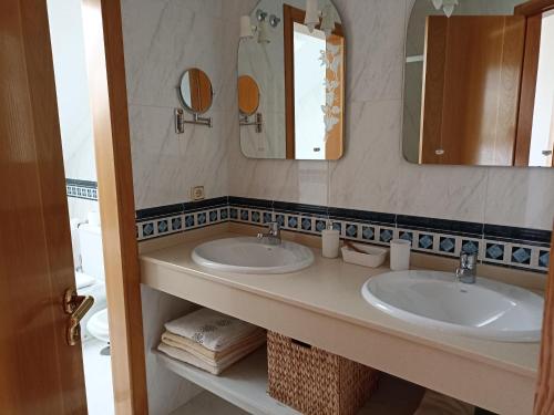 a bathroom with two sinks and two mirrors at Chalet en Combarro a pie de playa in Poio