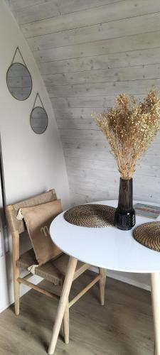 a white table and chairs with a vase on it at Domaine des Vignères in Saint-Maurice-de-Tavernole