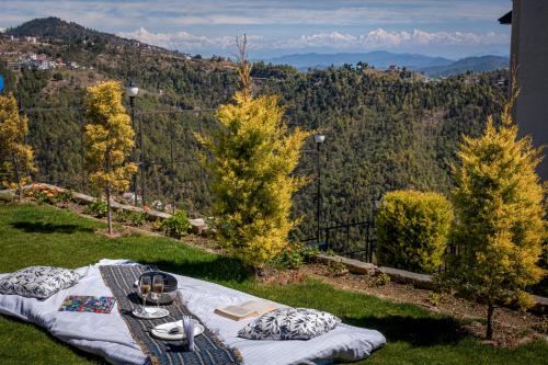 a picnic table on a hill with mountains in the background at Viable Inn by Vista Stays in Mukteswar