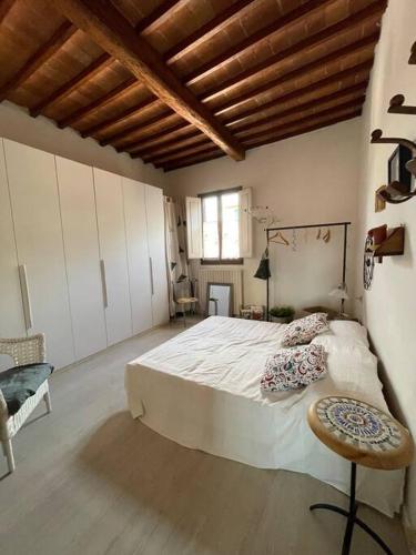a large bedroom with a large bed and a chair at Terratetto Montelupo Fiorentino in Montelupo Fiorentino