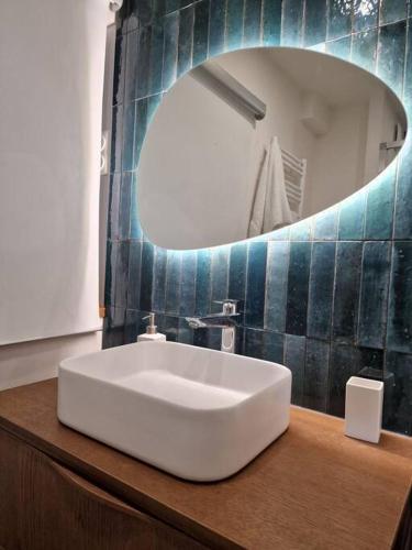 une salle de bain avec un lavabo blanc et un miroir dans l'établissement Pont de Sèvres : Appart neuf proche Paris, à Sèvres