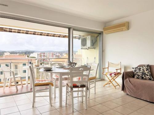 une salle à manger avec une table et des chaises et un balcon dans l'établissement Charmant T2 climatisé, proche plage, 4 couchages - Le Lavandou - FR-1-251-477, au Lavandou