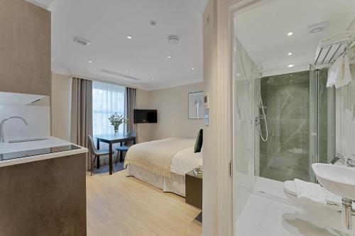 a bathroom with a bed and a sink and a shower at Cleveland Residences Paddington in London