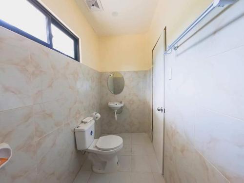 een badkamer met een toilet, een wastafel en een raam bij Happy Sunset's Inn in Larena
