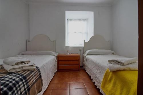 1 dormitorio con 2 camas, vestidor y ventana en Casa de Mila en Creciente Pontevedra, en Crecíente