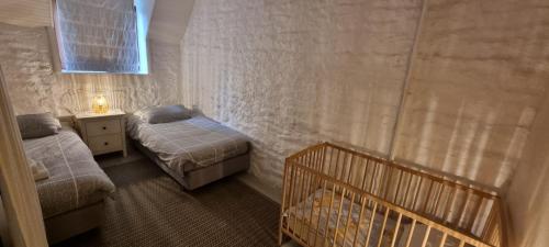 a bedroom with two beds and a crib in it at Gites Ferme de la Baie in Roz-sur-Couesnon