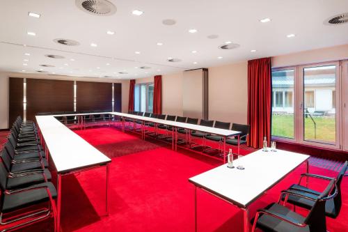 a conference room with tables and chairs on a red carpet at Sheraton Duesseldorf Airport Hotel in Düsseldorf