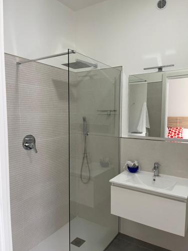 a bathroom with a glass shower and a sink at ViaRiva Rooms in Cagliari