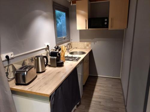 una piccola cucina con piano di lavoro e lavandino di Chalet 5 personnes vallée du lot a Laburgade