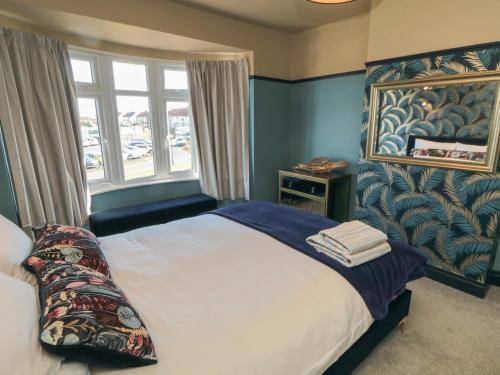 een slaapkamer met een bed en een groot raam bij Driftwood House in Redcar