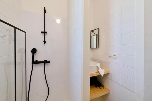 ein weißes Badezimmer mit Dusche und Waschbecken in der Unterkunft Clemence Green, Villa Hostal Naou Hossegor- wifi - sauna - salle de sport - netflix in Soorts-Hossegor