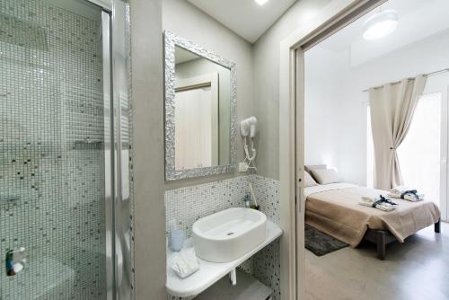 y baño con lavabo, espejo y ducha. en Byron Rooms, en La Spezia