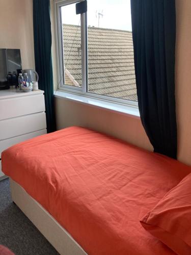 - une chambre avec un lit rouge et une fenêtre dans l'établissement Peaceful Place, à Mansfield