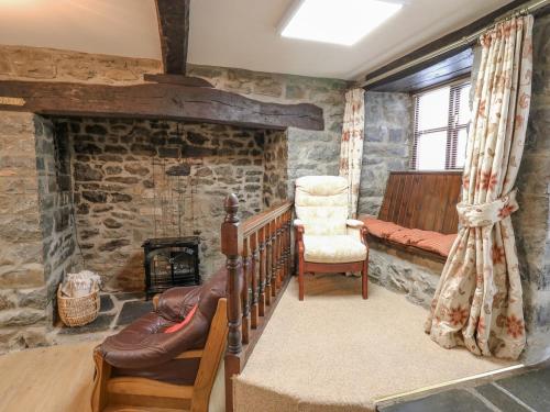 a living room with a staircase and a stone wall at The Searle in Llandrindod Wells